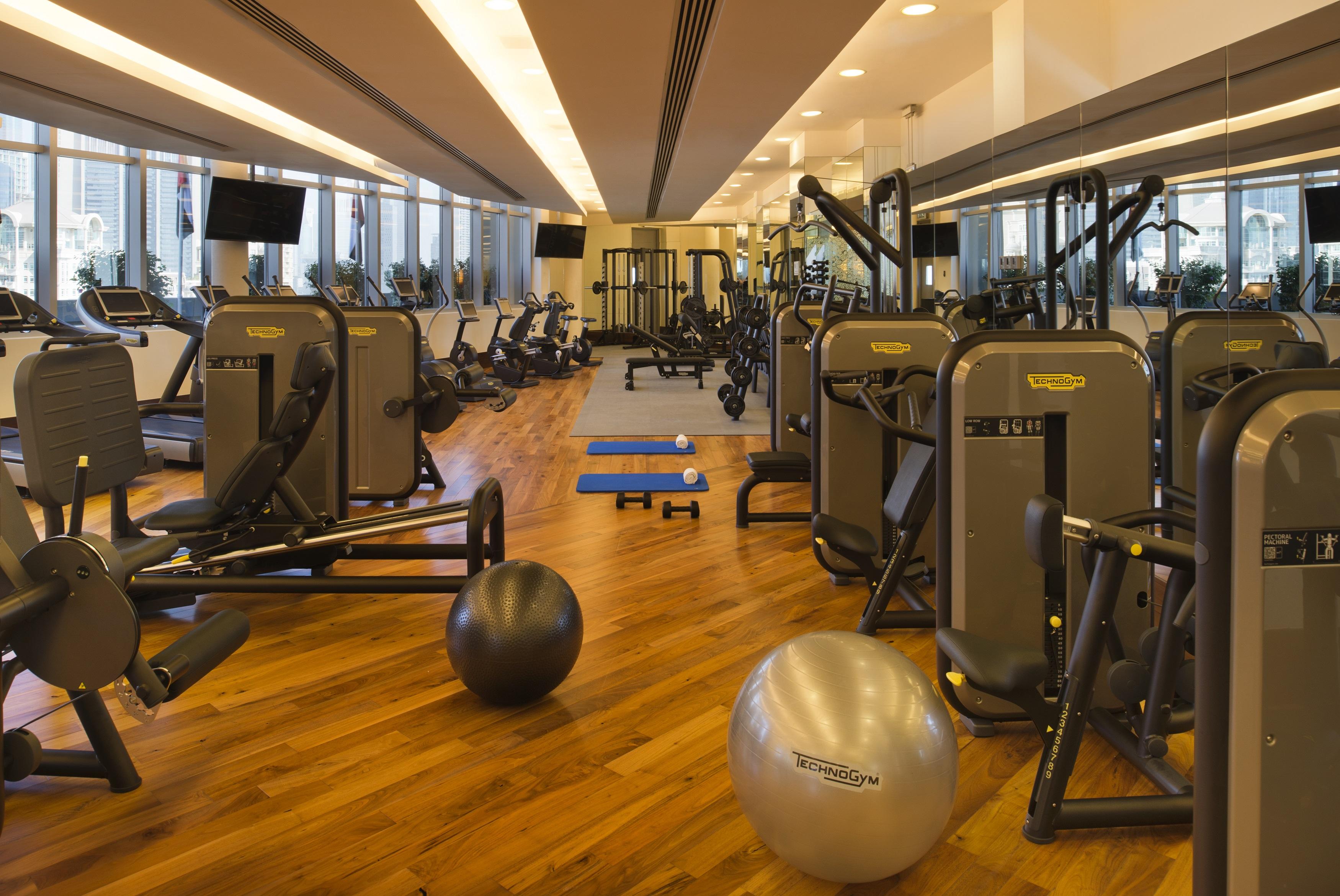 Kempinski Central Avenue Dubai Hotel Buitenkant foto The photo shows a modern gym interior with various fitness equipment. There are several exercise machines arranged neatly, including weight machines and cardio equipment, such as treadmills and stationary bikes. The flooring appears to be wooden, con